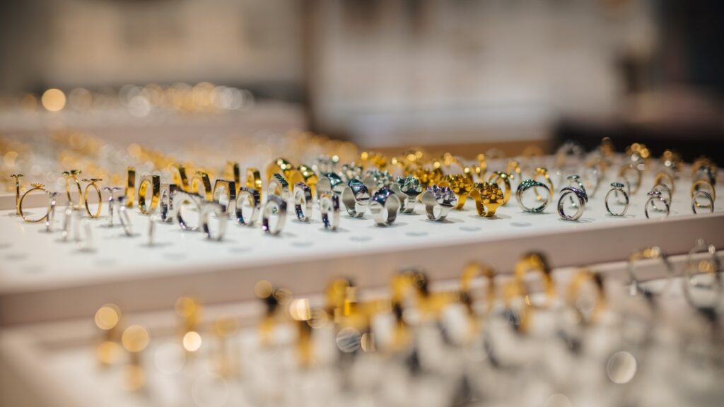 Smyckesdisplay med ringar i guld- och silvertoner presenterade i en smyckesbutik.