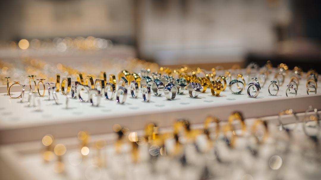 Smyckesdisplay med ringar i guld- och silvertoner presenterade i en smyckesbutik.