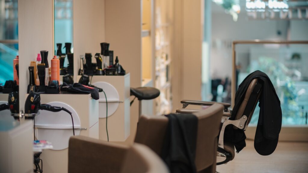 Frisörsalong med stylingstationer, hårvårdsprodukter och frisörstolar i modern salongsmiljö.