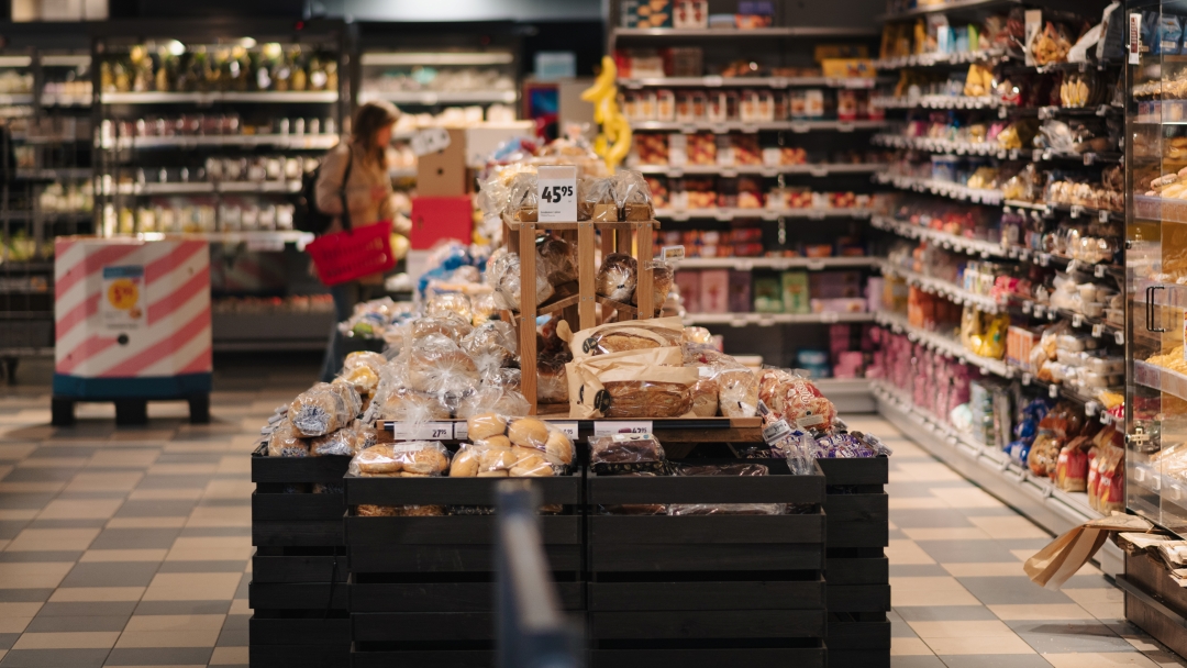 Bröd- och bakverksavdelning i livsmedelsbutik med färska produkter utställda på centralt bord.