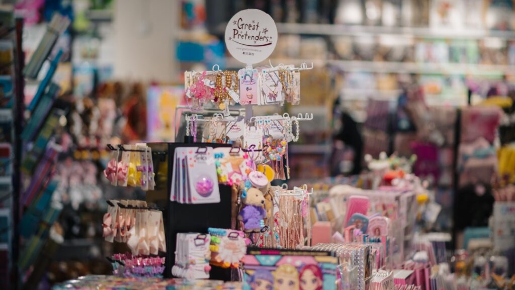 Ställ med färgglada håraccessoarer, smycken och leksaker i butik med produkter för barn.