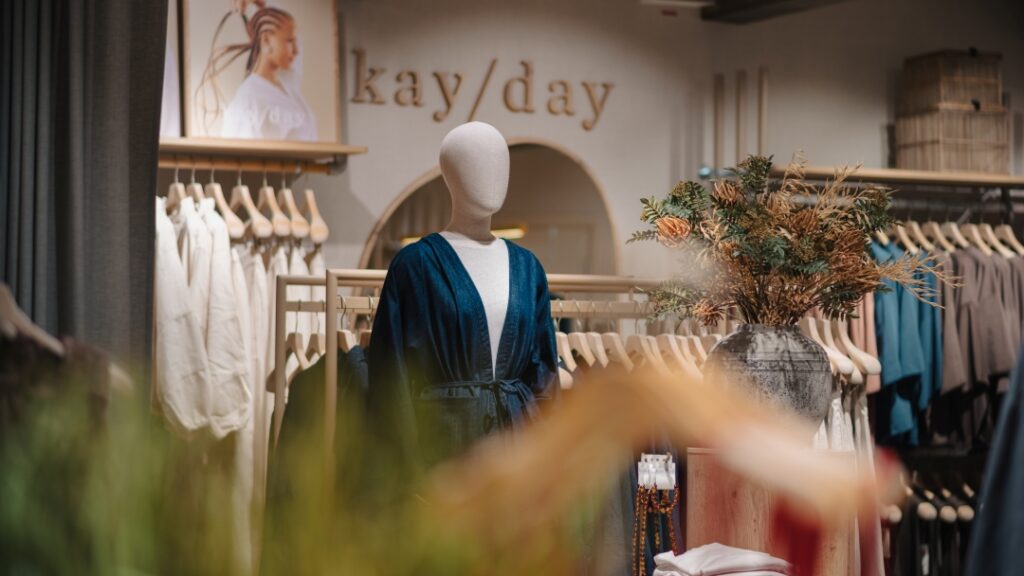 Klädbutik med skyltdocka, klädställningar och loungewear presenterat i en lugn butiksmiljö.